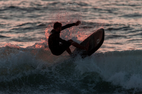 Un surfeur au coucher de soleil